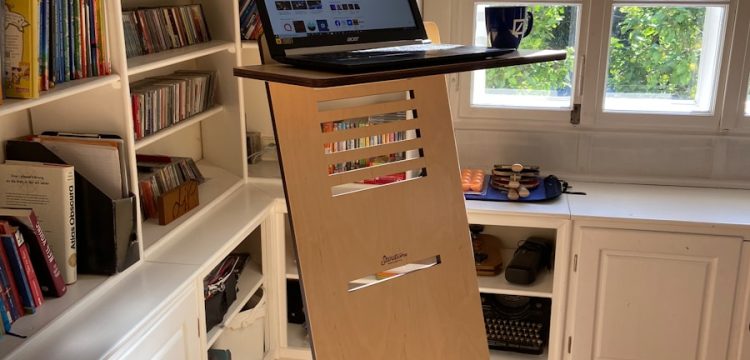 black laptop computer on white wooden book shelf
