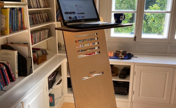 black laptop computer on white wooden book shelf