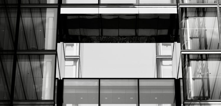 Woman walking through modern office building windows